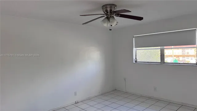 an empty room with a window and a fan