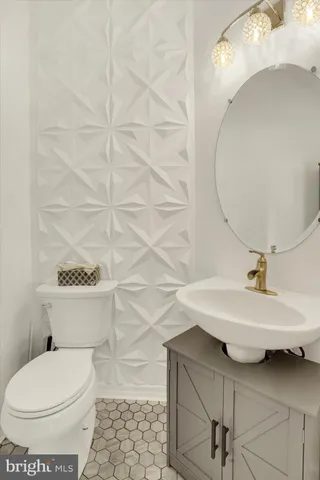 a bathroom with a sink a toilet and a mirror