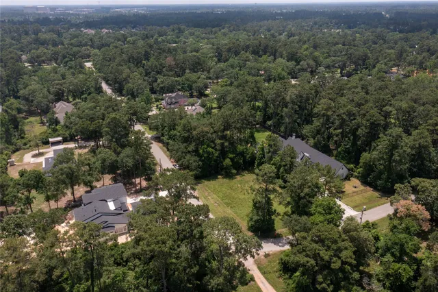 an aerial view of residential house with outdoor space and trees all around