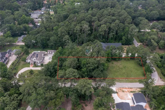 an aerial view of residential house with outdoor space and trees all around