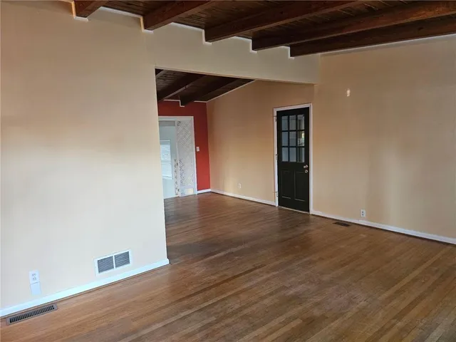 a view of an empty room with wooden floor
