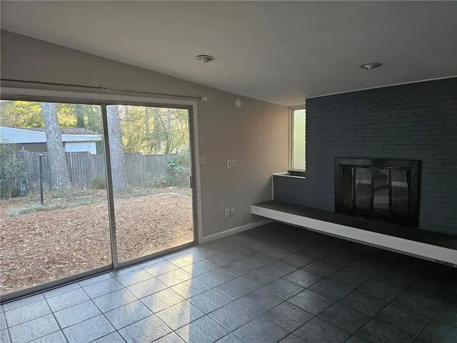 a view of an empty room window and fire place