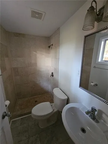 a bathroom with a toilet sink a mirror and vanity