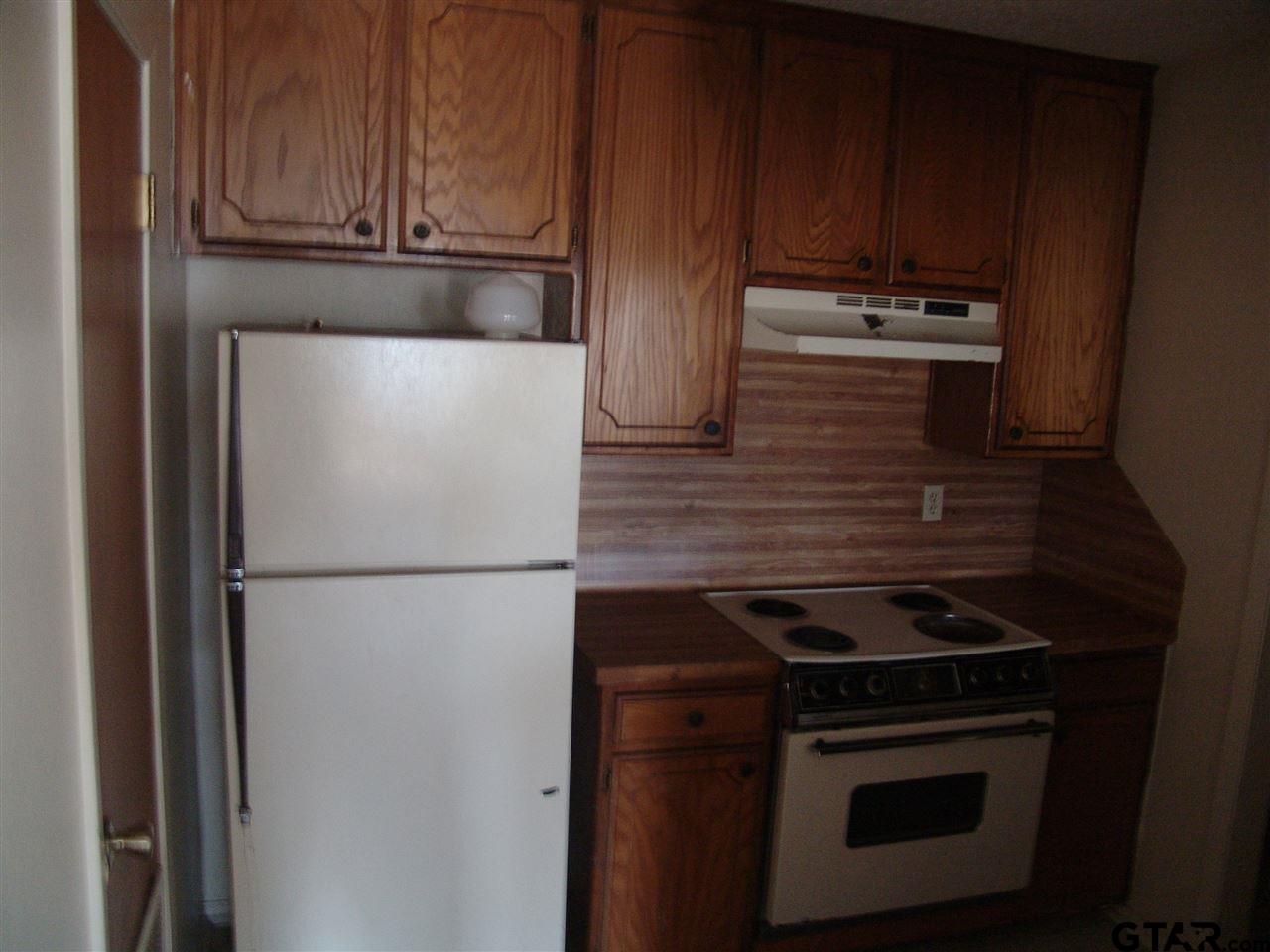 2809 West Shaw Street Tyler, TX 75701 - Photo 2 of 3 a white refrigerator freezer and a stove sitting inside of a kitchen