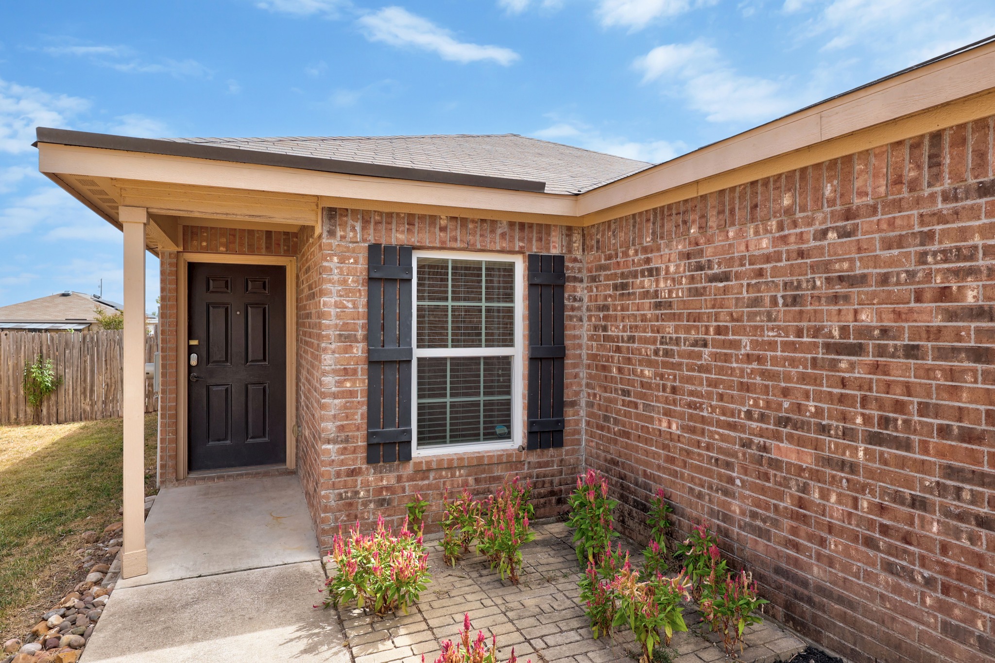 228 Millers Loop Jarrell, TX 76537 - Photo 2 of 26 Classic brick exterior elements and dark shutters frame the welcoming entrance walkway.