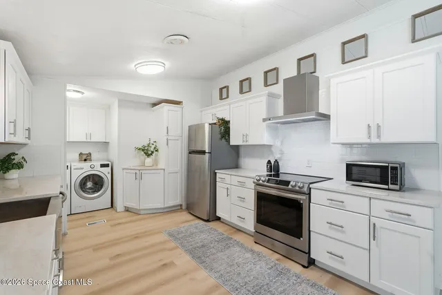 a kitchen with white cabinets and white appliances