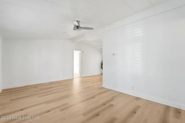 a view of empty room with wooden floor and a potted plant