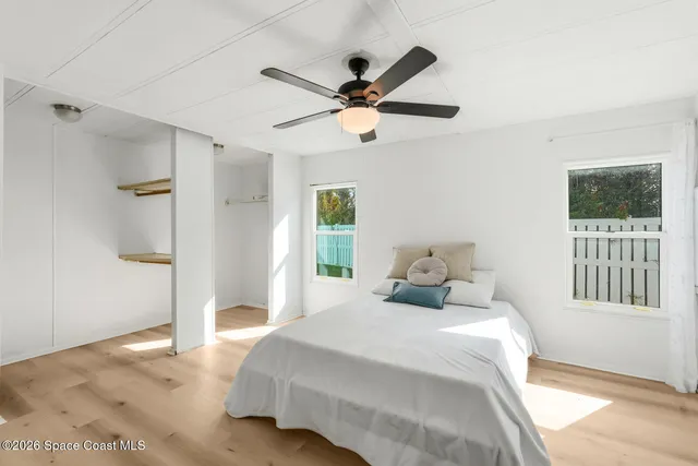 a bedroom with a bed and a ceiling fan