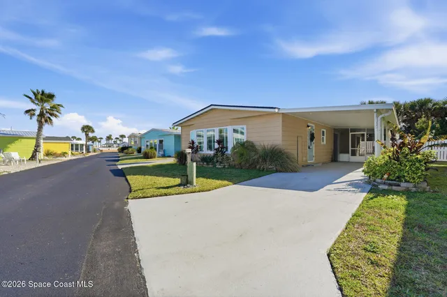 a view of a house with a yard and potted plants