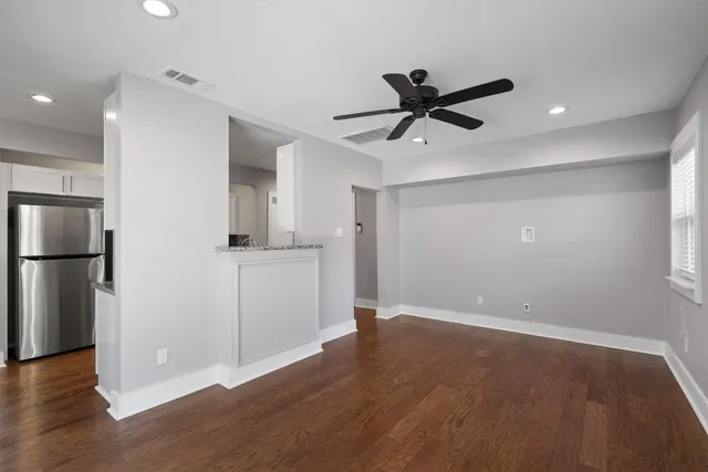 a kitchen with stainless steel appliances granite countertop a stove top oven a sink dishwasher and white cabinets with wooden floor