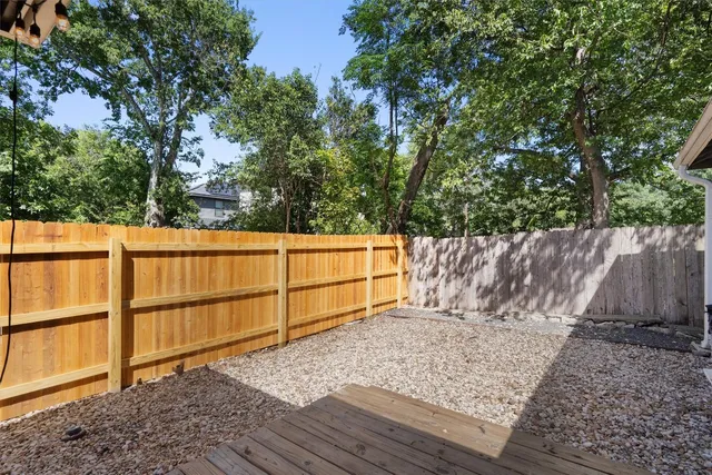 a view of deck with two chairs and wooden fence