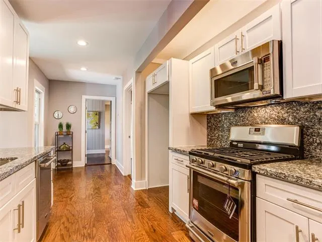 a kitchen with stainless steel appliances granite countertop a sink and cabinets