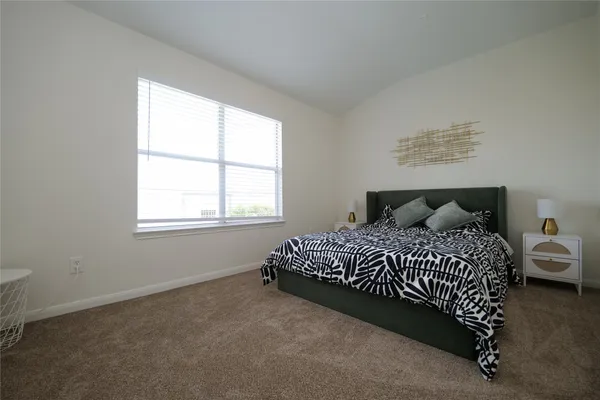 a large bed sitting in a bedroom next to a window