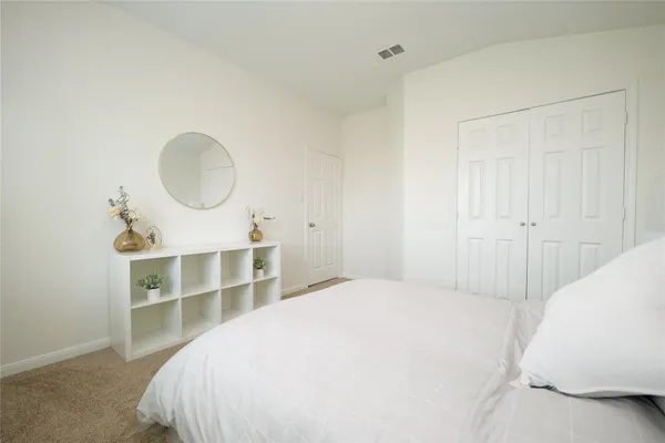 a large bed sitting in a bedroom next to a window