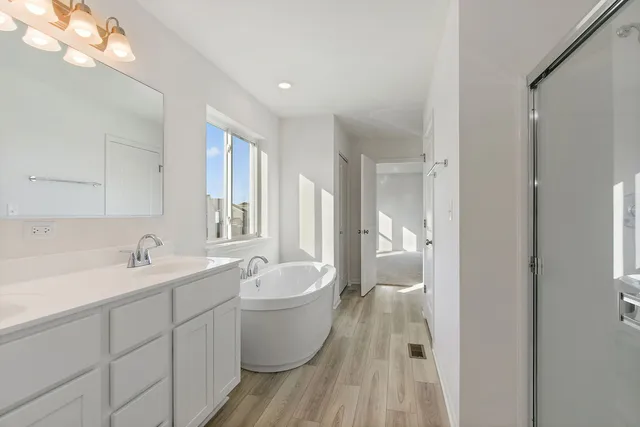 a bathroom with a white tub sink toilet and mirror