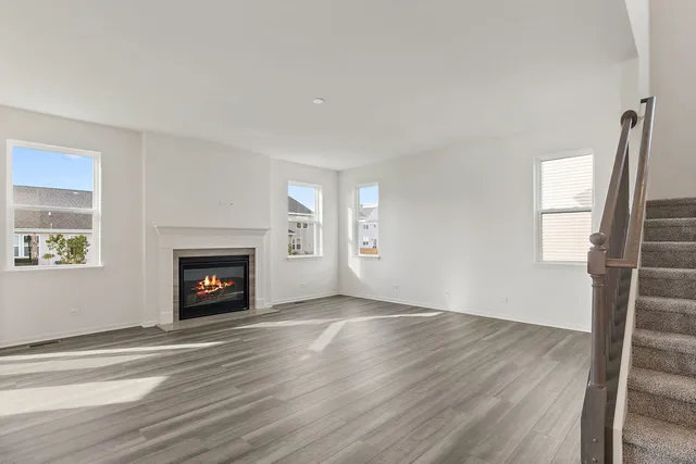 an empty room with windows a fireplace