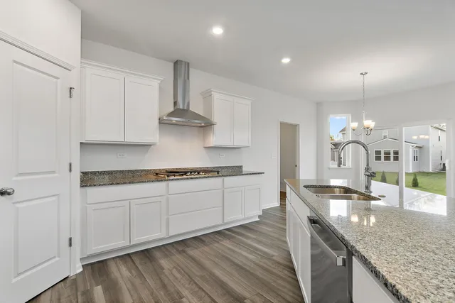 a kitchen with stainless steel appliances granite countertop a sink stove and cabinets