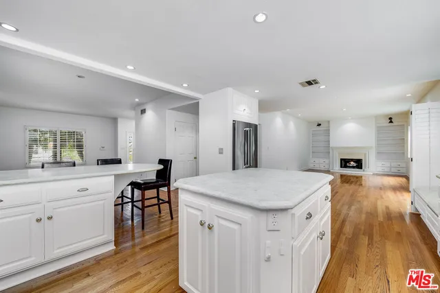 a kitchen with stainless steel appliances granite countertop a stove a sink and white cabinets