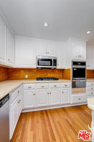 a kitchen with stainless steel appliances a refrigerator sink and cabinets
