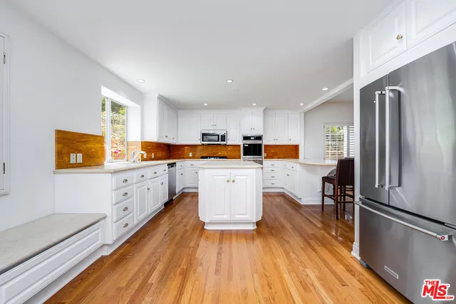 a view of a living room and kitchen with a wooden floor