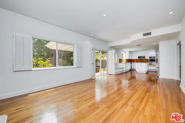 a view of empty room with wooden floor and fireplace
