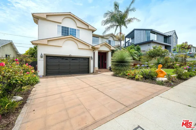 a view of a house with a yard and potted plants