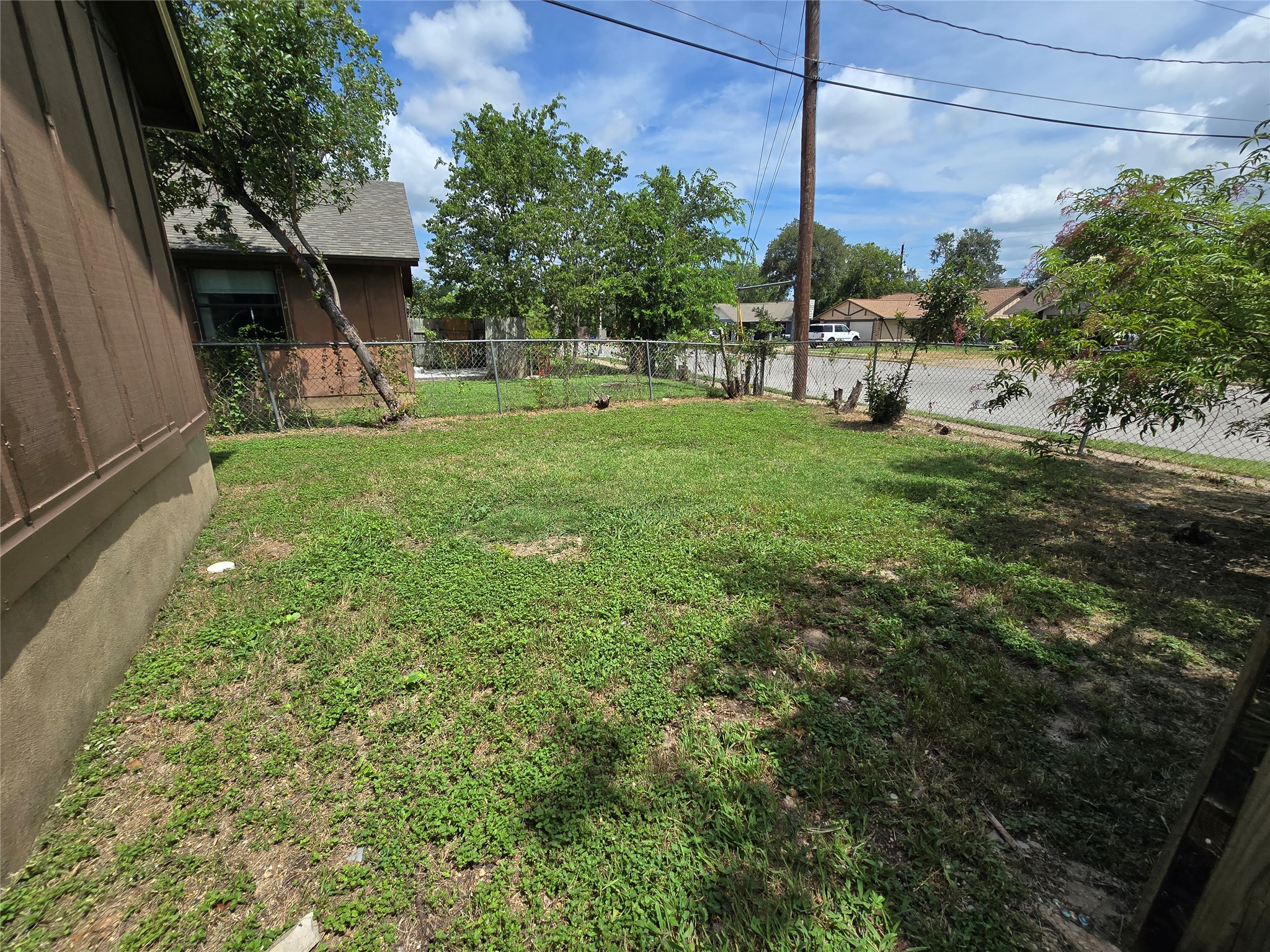 6206 Buffalo Pass, Unit A Austin, TX 78745 - Photo 23 of 24 A well-kept yard offers a private retreat with mature trees and a sturdy chain-link fence.