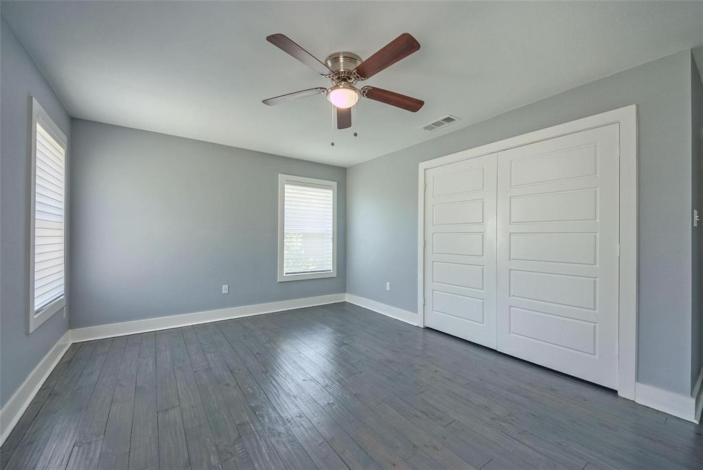 11224 Jamestown Road Dallas, TX 75230 - Photo 26 of 40 an empty room with wooden floor chandelier fan and windows