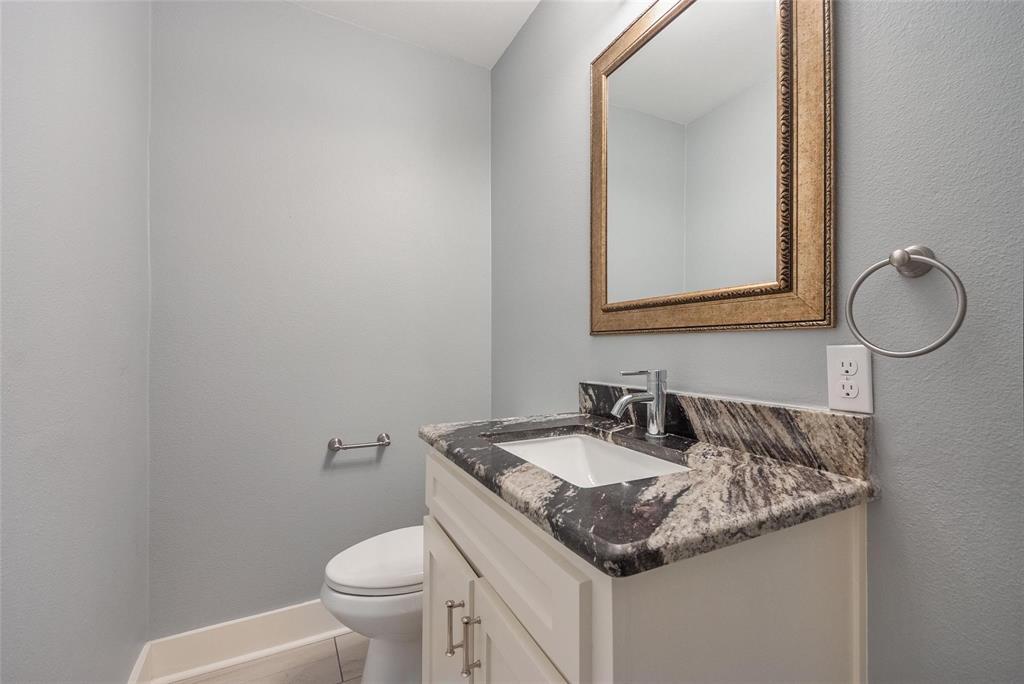11224 Jamestown Road Dallas, TX 75230 - Photo 31 of 40 a bathroom with a granite countertop toilet sink and mirror