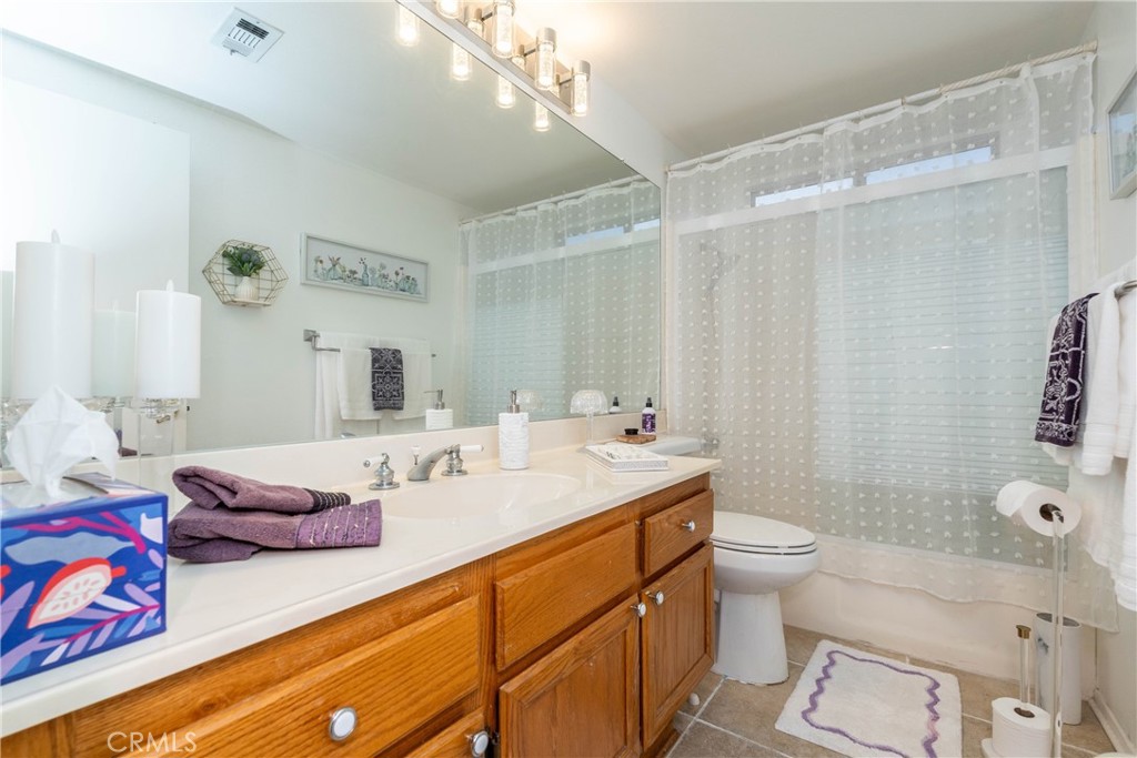 26592 Braddock Road Menifee, CA 92586 - Photo 16 of 25 a bathroom with a granite countertop sink mirror vanity and toilet