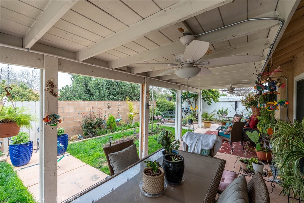 26592 Braddock Road Menifee, CA 92586 - Photo 20 of 25 a view of a patio with chairs potted plants and floor to ceiling window