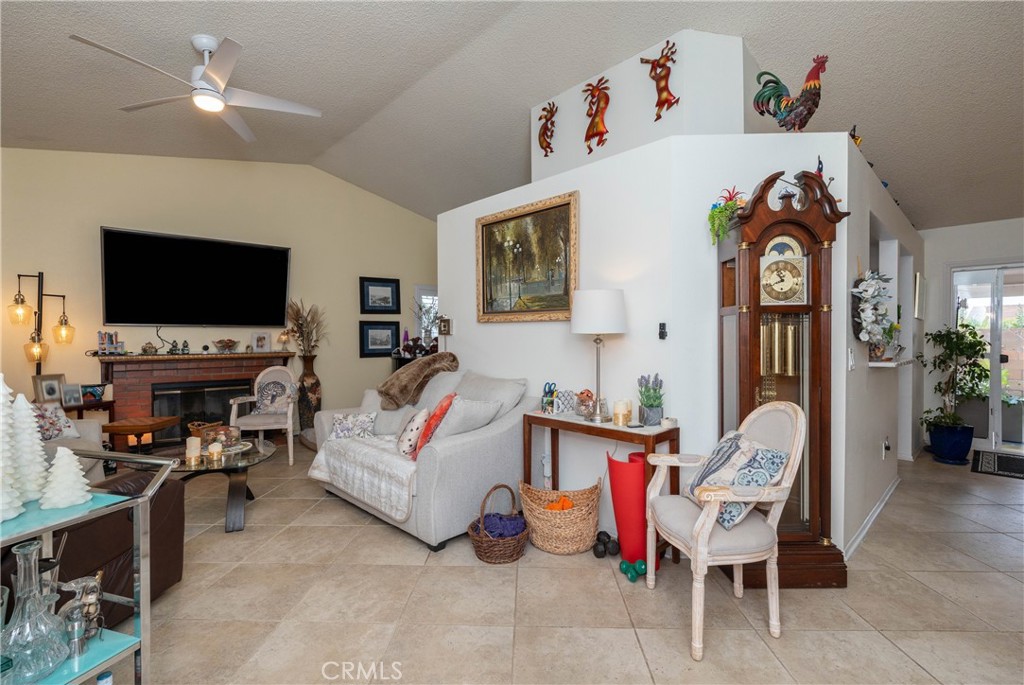 26592 Braddock Road Menifee, CA 92586 - Photo 6 of 25 a living room with furniture a flat screen tv and a fireplace