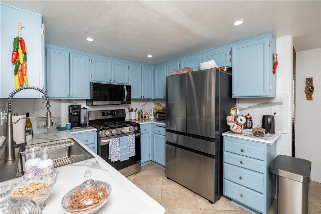 26592 Braddock Road Menifee, CA 92586 - Photo 10 of 25 a kitchen with stainless steel appliances granite countertop a refrigerator a stove top oven a sink and dishwasher