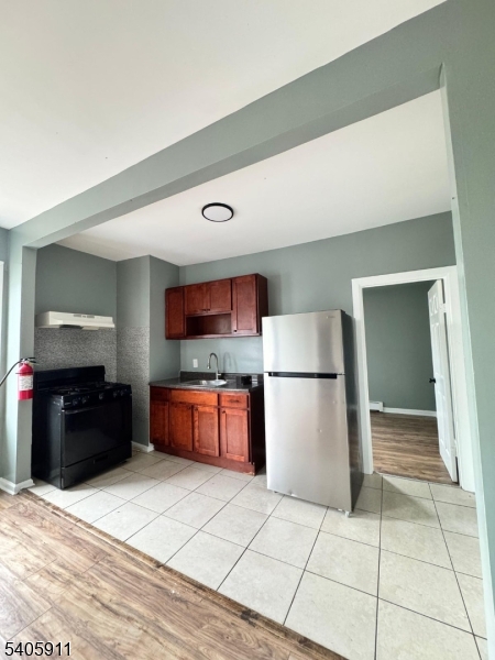 a kitchen with a refrigerator and a stove top oven