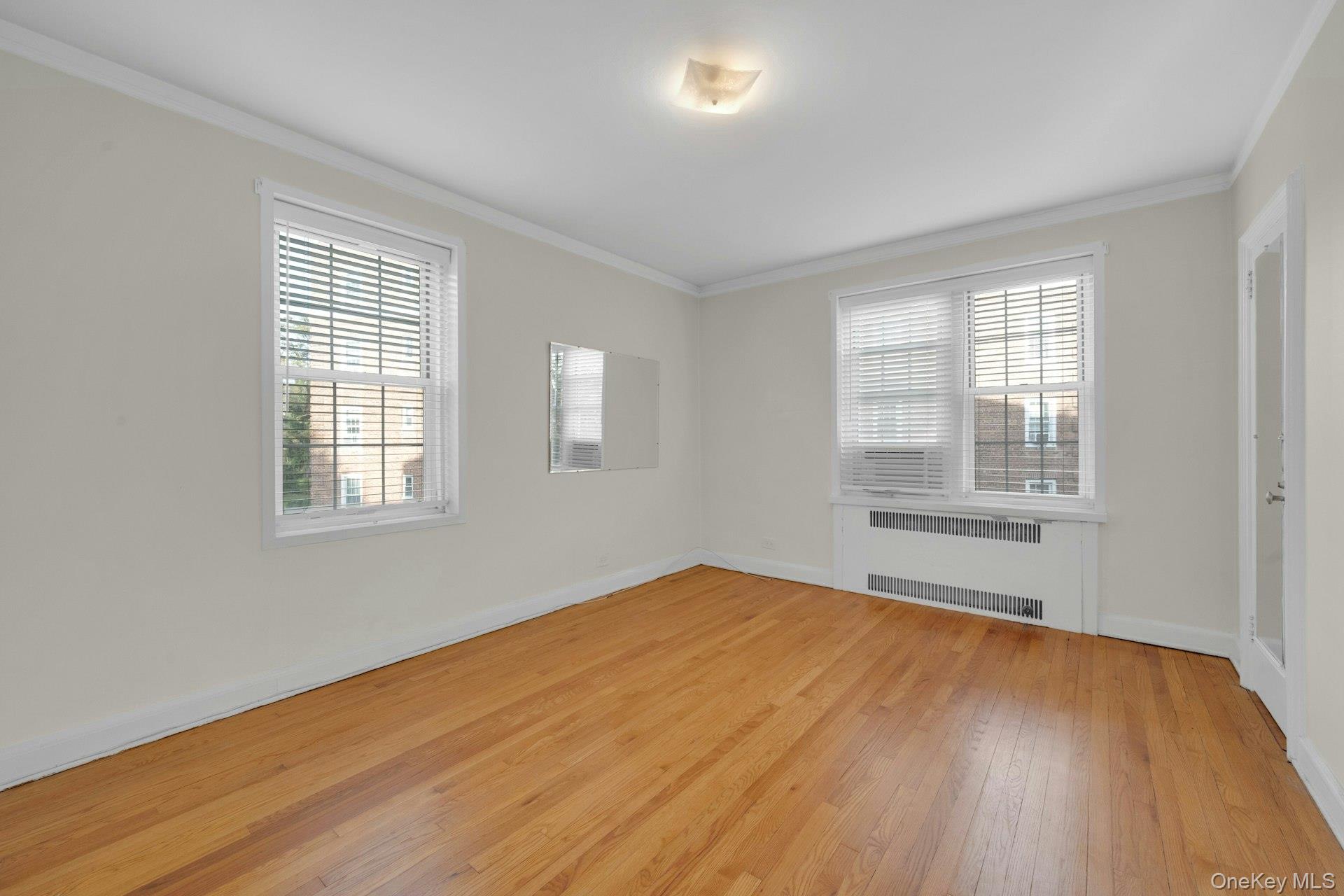 5 Midland Gardens, Unit 3M Bronxville, NY 10708 - Photo 15 of 19 Primary Bedroom with crown molding, light wood finished floors, and radiator