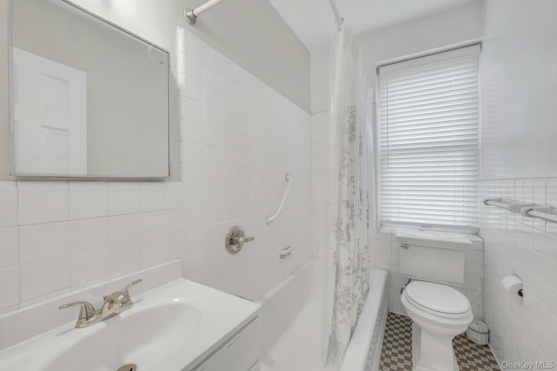 5 Midland Gardens, Unit 3M Bronxville, NY 10708 - Photo 18 of 19 Full bath featuring tile walls, vanity, tile patterned flooring, and shower / bath combo with shower curtain