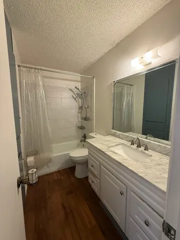 a bathroom with a granite countertop sink toilet and shower