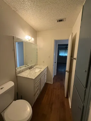 a bathroom with a sink and mirror with toilet