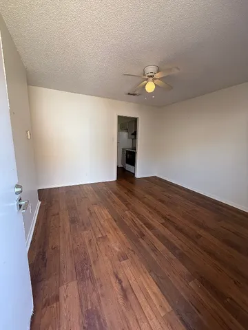 a view of empty room with wooden floor
