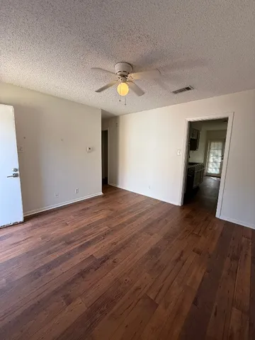 a view of empty room with wooden floor