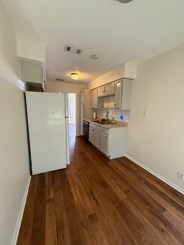 a kitchen with a refrigerator and a stove top oven