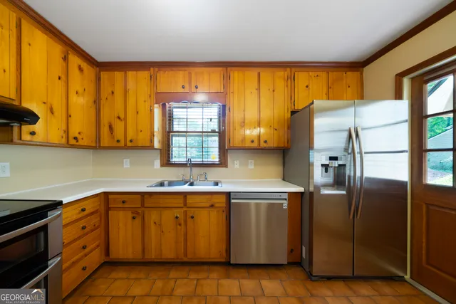 a kitchen with stainless steel appliances granite countertop a refrigerator and a sink