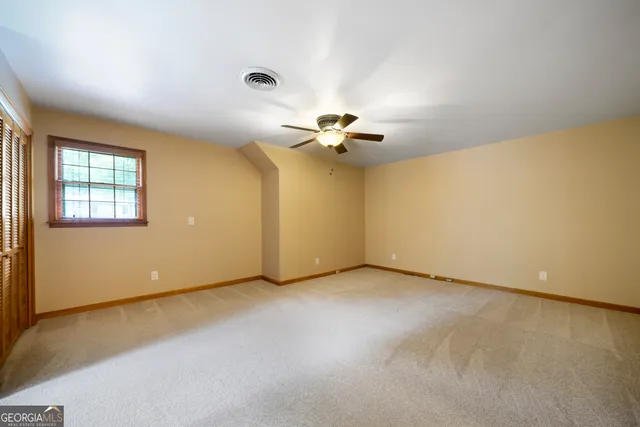 a view of an empty room with a chandelier fan