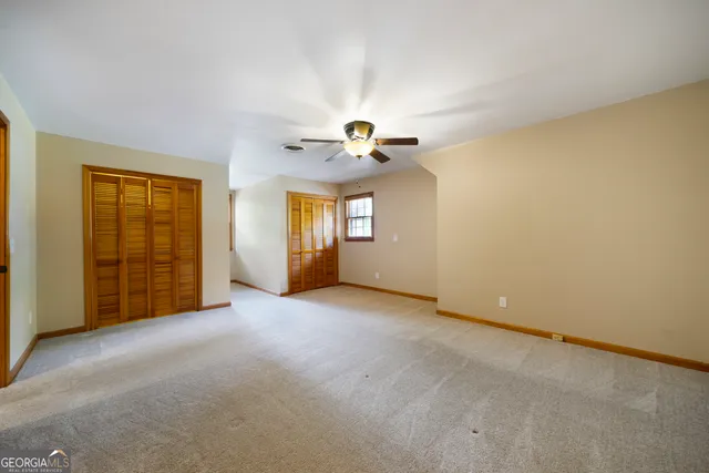 an empty room with windows and closet