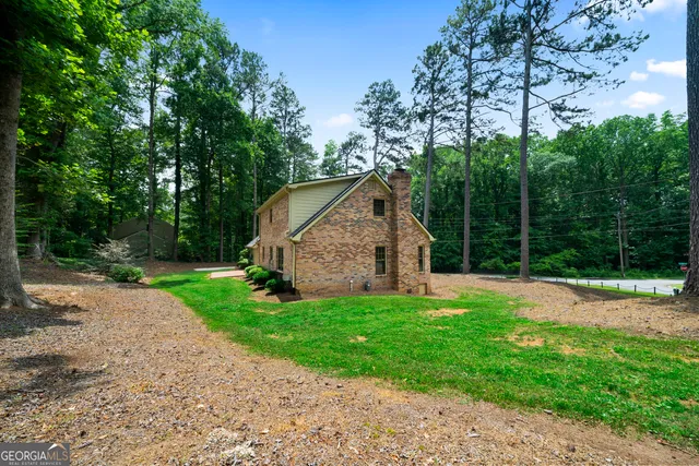 a view of a house with backyard and a tree