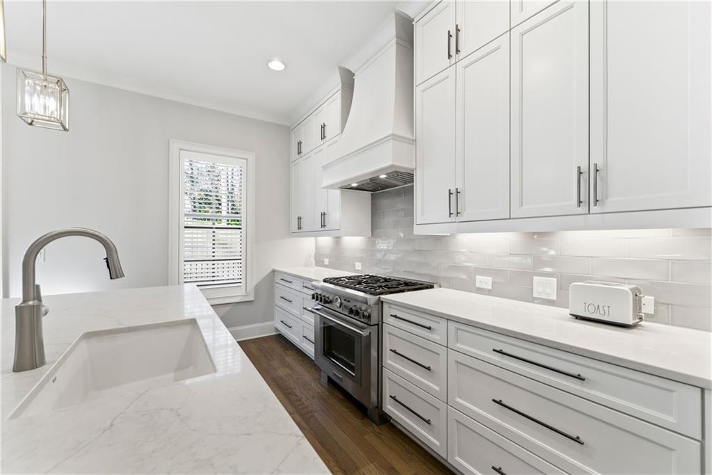 2131 Bellrick Road Northwest Atlanta, GA 30318 - Photo 16 of 57 a kitchen with stainless steel appliances granite countertop a stove a sink and white cabinets