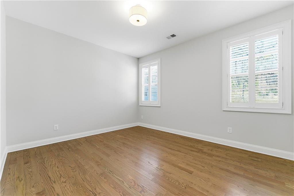 2131 Bellrick Road Northwest Atlanta, GA 30318 - Photo 23 of 57 an empty room with wooden floor and windows