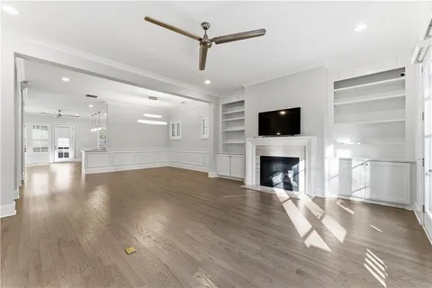 a view of a livingroom with a fireplace a chandelier and wooden floor