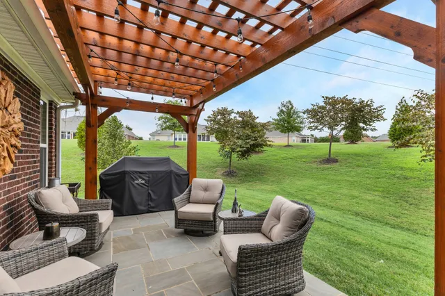 a view of yard from deck with patio