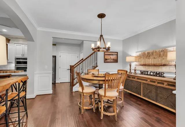 a view of a dining room with furniture wooden floor and chandelier